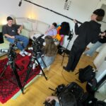Videointerview-Setup mit zwei Kameras, Tonangel, Interviewerin und einer Protagonistin gegenübersitzend.